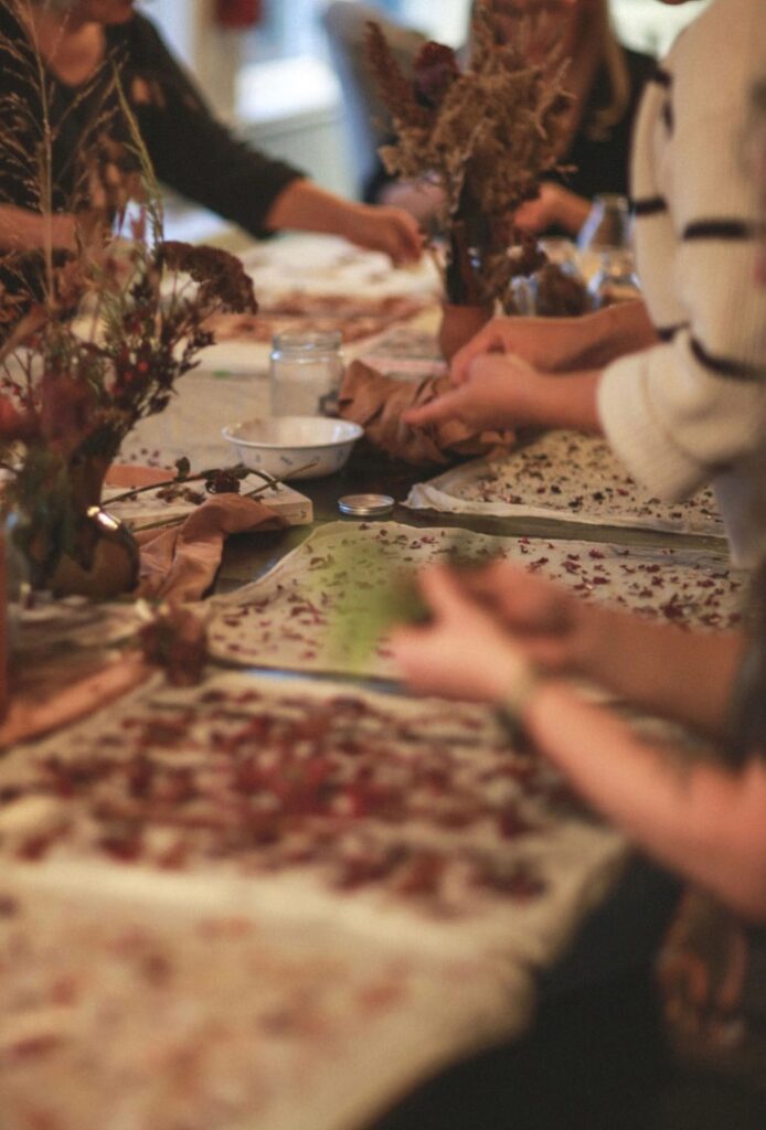 hands placing dried flowers onto cotton bandanas